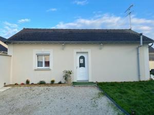 una casa blanca con una puerta blanca y un patio en Charmante maison au calme, en Sainte-Maure