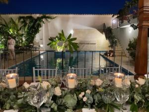 - une table avec des fleurs et des bougies à côté de la piscine dans l'établissement Karakali Boutique Hotel, à Mompos