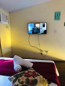 een kamer met een tv aan de muur en een bed bij Pousada Santé in Guarujá