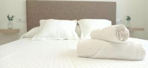 stos ręczników na białym łóżku w obiekcie A Capelada-Céntrico apartamento en Cedeira w mieście Cedeira