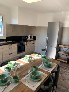 a kitchen with a wooden table with green dishes on it at Résidence « les Gets » Location T4 Vieux-Boucau-Les-Bains in Vieux-Boucau-les-Bains