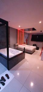 um quarto com 2 camas e uma banheira em Desejo Motel em Araçoiaba da Serra