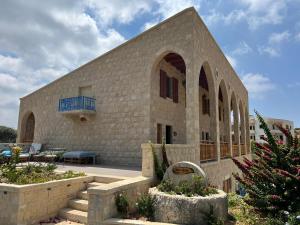 a large stone building with stairs in front of it at Domaine des Oliviers in Batroûn