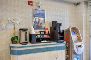 a coffee shop with a cash register on a counter at Motel 6-Grande Prairie, AB in Grande Prairie