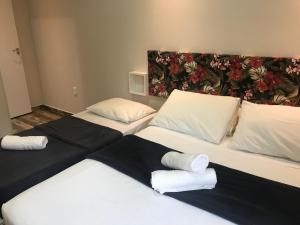 Dos camas en una habitación con toallas. en Ondas da Guarda Moradas, en Guarda do Embaú