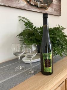 een fles wijn zittend op een tafel met twee glazen bij Apartment Panoramablick in Bad Bergzabern
