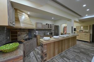 a large kitchen with wooden cabinets and a counter top at Domaine des Oliviers in Batroûn