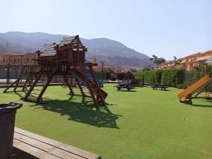 un parque infantil con un tobogán en un césped verde en Twin House in Telal, en Ain Sokhna