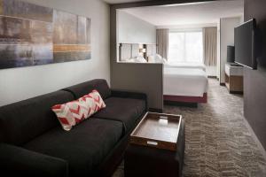 a hotel room with a couch and a bed at Sonesta Select Seattle Renton Suites in Renton