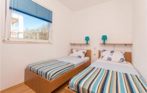 2 camas en una habitación pequeña con ventana en 2 Bedroom Awesome Apartment In Biograd Na Moru, en Biograd na Moru