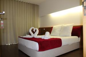 a bedroom with two swans decorations on a bed at Casa Avé Maria in Fátima