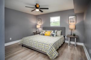 Un dormitorio con una cama y un ventilador de techo. en Spacious Home Near Downtown San Antonio, en San Antonio