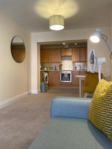 a living room with a blue couch and a kitchen at 1 bedroom apartment in the heart of Bournemouth in Bournemouth