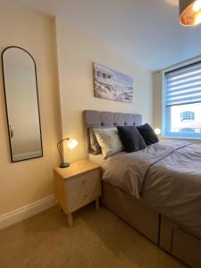 a bedroom with a bed and a large mirror at 1 bedroom apartment in the heart of Bournemouth in Bournemouth