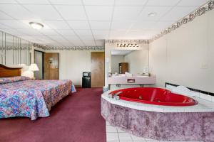 a hotel room with a large tub in a bedroom at Candlewick Inn and Suites in Eureka Springs