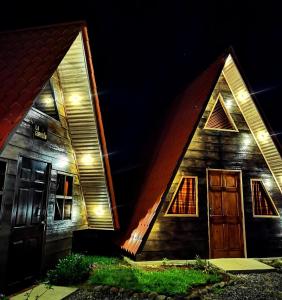 a barn with a door and windows at night at Casa Tucan Glamping in Turrialba