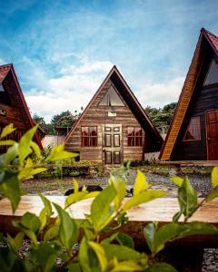 a wooden house with red windows in front of it at Casa Tucan Glamping in Turrialba