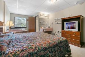 a bedroom with a bed and a flat screen tv at Candlewick Inn and Suites in Eureka Springs