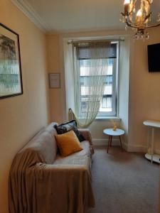 ein Wohnzimmer mit einem Sofa und einem Fenster in der Unterkunft Cozy Central Apartment in Inverness