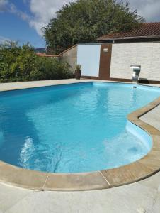 a large swimming pool with blue water at Quarto Inteiro Privado - 3km Oktoberfest in Blumenau