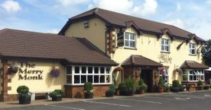 a inn with a merry monkey sign on the front of it at The Merry Monk in Ballina