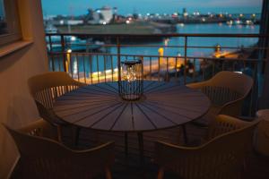 a table and chairs on a balcony with an umbrella at Bheaven I Sea Pilot Premium Apartment in Bremerhaven