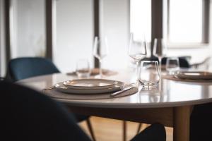 a table with plates and wine glasses on it at Bheaven I Sea Pilot Premium Apartment in Bremerhaven