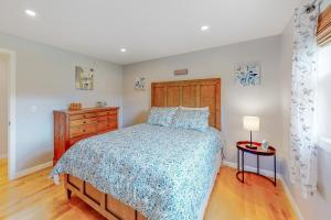 1 dormitorio con cama con colcha azul y mesa en Randall Meadows en Pittsford