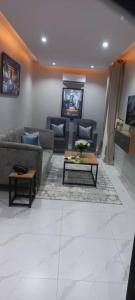 uma sala de estar com sofás e uma mesa de centro em Choice Suites Signature em Ikeja