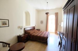 a bedroom with a bed and a table and a window at Abrahams Herberge - Beit Ibrahem in Bethlehem