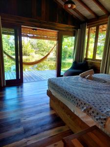 um quarto com uma cama num quarto com janelas em Woodstock Bungalow - Barra Grande - condo frente praia em Barra Grande