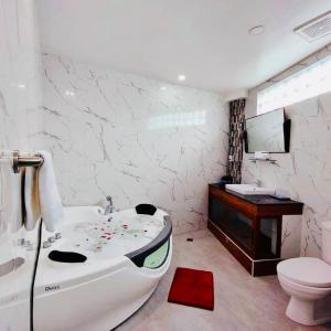 a bathroom with a tub and a toilet and a sink at III Felix Villas in Naga