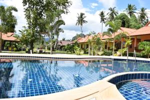 una piscina en un complejo con palmeras en Sawaddee Aonang Resort, en Ao Nang Beach 35 fotos más