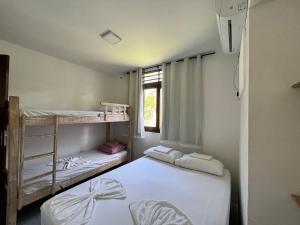 two bunk beds in a room with a window at Chalés Praias Brasileiras in Maragogi
