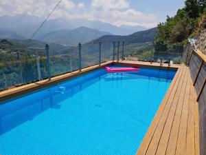 une piscine d'eau bleue et des montagnes en arrière-plan dans l'établissement DA ERCOLE casa vacanze di lusso con giardino, piscina e idromassaggio., à Vigneta