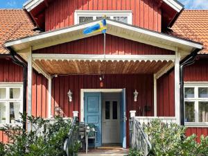 Örsjöにある8 person holiday home in ÖRSJÖ-By Traumの青い扉と日よけの赤い家