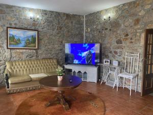 sala de estar con sofá, mesa y TV en Casas Solar da Torre 1, en Póvoa de Varzim