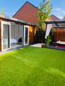 a yard with a large lawn and a house at MeeZee Pearl Double Bed Lodge With Free Parking in Manchester