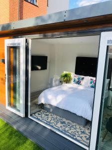 1 dormitorio con 1 cama dentro de una puerta de cristal en MeeZee Pearl Double Bed Lodge With Free Parking, en Mánchester