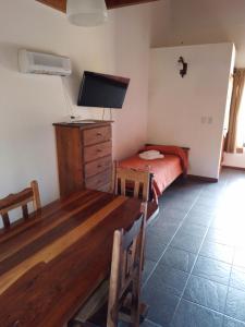 1 dormitorio con mesa, cama y TV en Barranca Del Indio en Merlo