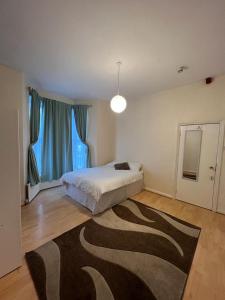 a bedroom with a bed and a rug on the floor at Bruce Rooms in London