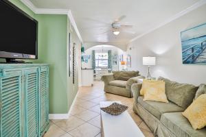 a living room with two couches and a flat screen tv at Barefoot Beach Resort F104 in Clearwater Beach