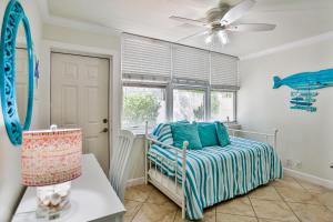 Schlafzimmer mit einem Bett und einem Deckenventilator in der Unterkunft Barefoot Beach Resort F104 in Clearwater Beach