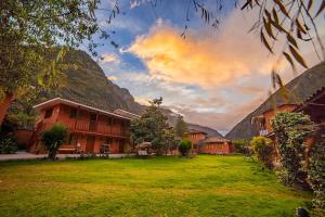 a large yard with a building and a mountain at LILIUM VALLEY in Ollantaytambo