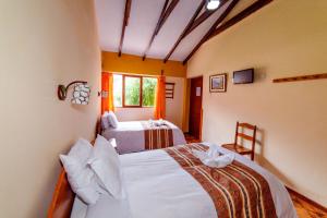 1 dormitorio con 2 camas y ventana en LILIUM VALLEY, en Ollantaytambo