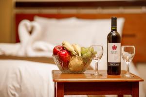 una mesa con una botella de vino y un bol de fruta en LILIUM VALLEY, en Ollantaytambo
