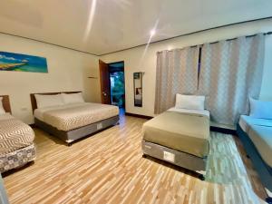 two beds in a hotel room with two beds at Road Garden Villa in General Luna
