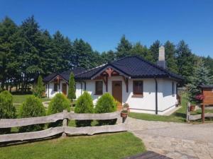 una piccola casa con una recinzione di fronte di Holiday homes near the lake, mini zoo a Gleźnowo