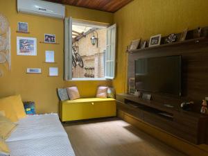 a bedroom with a tv and a bed and a window at Tao Station 752 in Porto Alegre