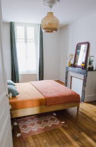 1 dormitorio con cama con espejo y ventana en Passage de l'Horloge en Auxerre